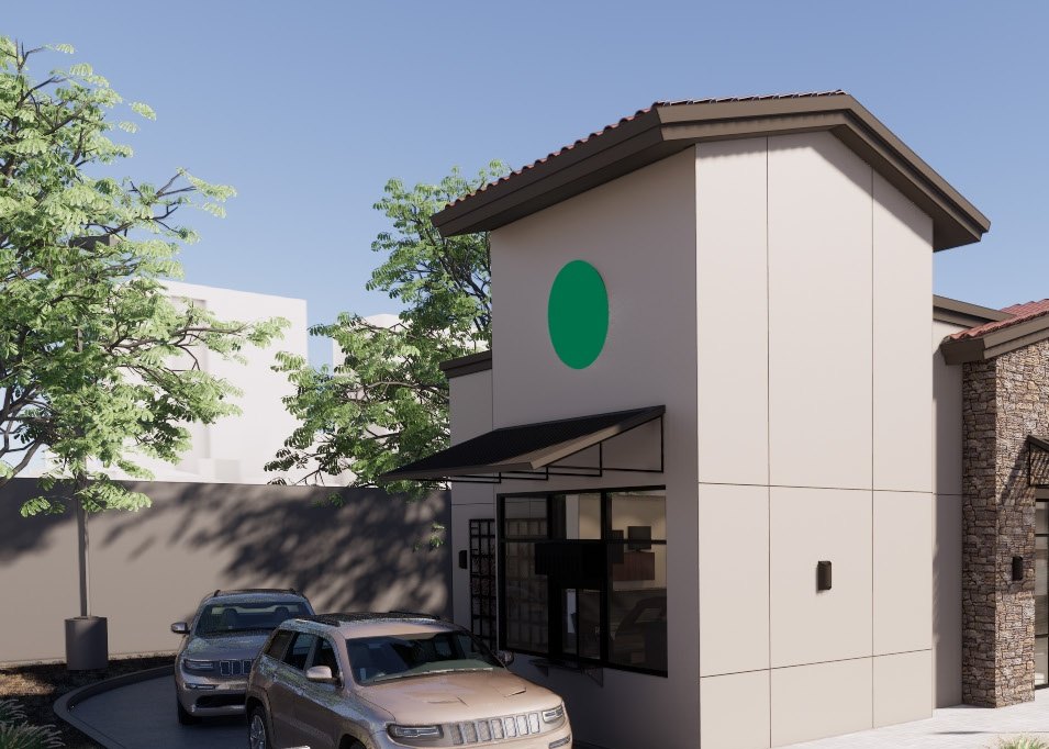 Retail pad with a stone-clad tower, beige stucco and a black-framed storefront